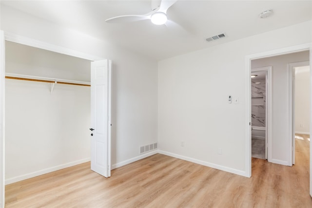 unfurnished bedroom with a closet, visible vents, baseboards, and wood finished floors