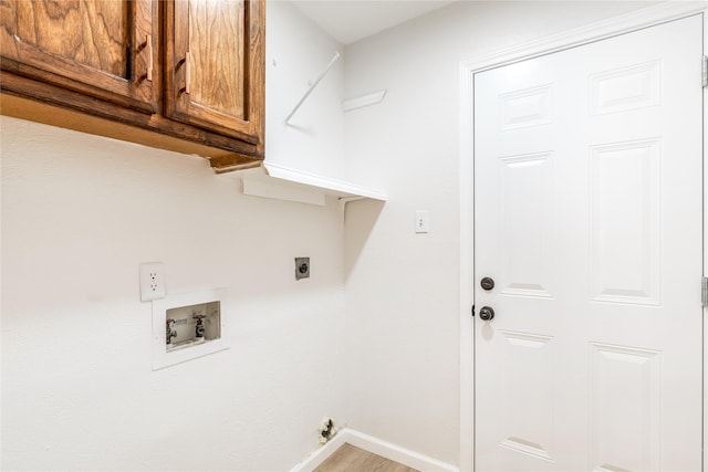 laundry room with electric dryer hookup, washer hookup, cabinet space, and baseboards