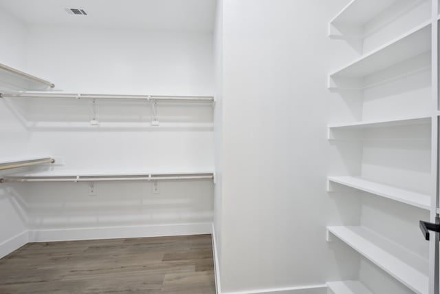 walk in closet with dark hardwood / wood-style flooring