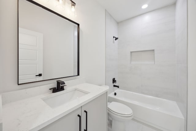 full bathroom featuring vanity, tiled shower / bath combo, and toilet