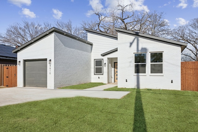 view of front of property with a garage and a front lawn