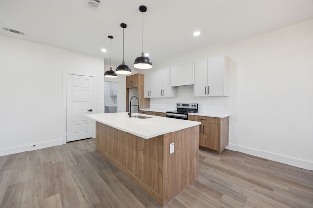 kitchen featuring sink, a kitchen island with sink, backsplash, white cabinets, and stainless steel electric range oven