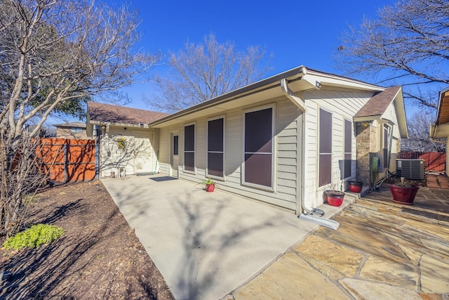 rear view of house with central AC unit and a patio