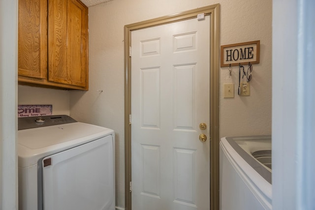 washroom featuring washing machine and dryer and cabinets