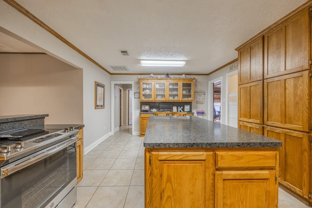 kitchen with crown molding, stainless steel range with electric cooktop, a kitchen island, and light tile patterned floors