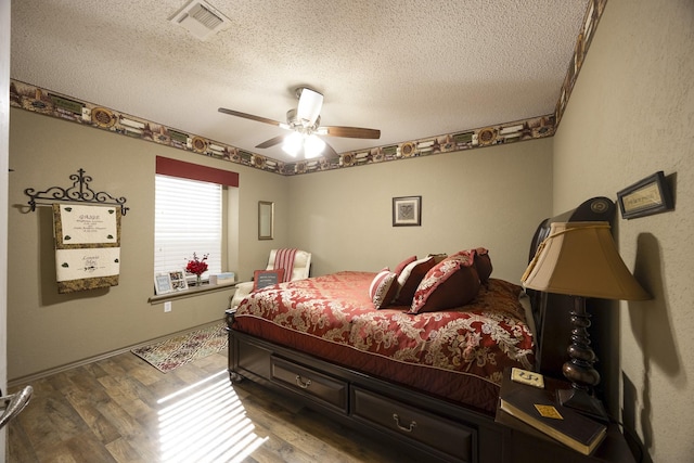 bedroom featuring wood-type flooring, ceiling fan, and a textured ceiling