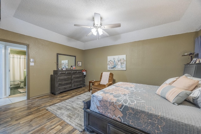 bedroom featuring ceiling fan, wood-type flooring, and a textured ceiling