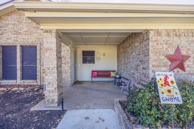 view of exterior entry with a patio