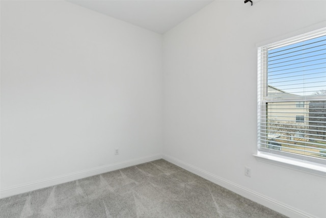 spare room featuring a wealth of natural light and light colored carpet