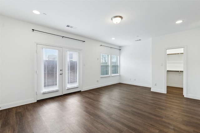 spare room with dark wood-type flooring and french doors