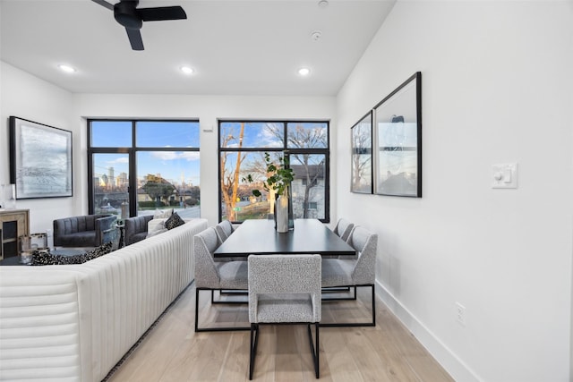 dining room with a wealth of natural light, ceiling fan, and light hardwood / wood-style flooring