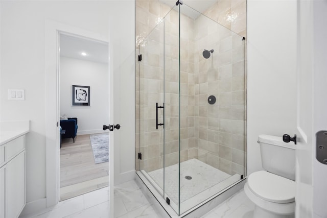 bathroom with vanity, a shower with shower door, and toilet