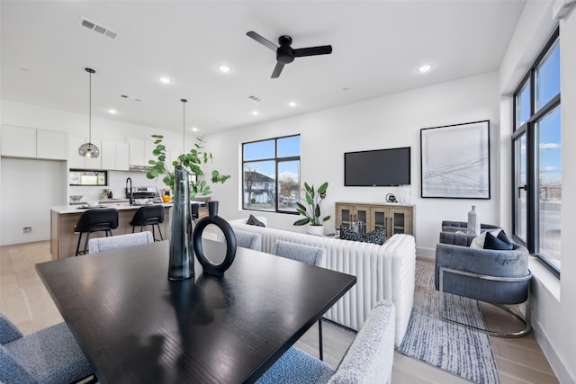 dining area with light hardwood / wood-style flooring and ceiling fan