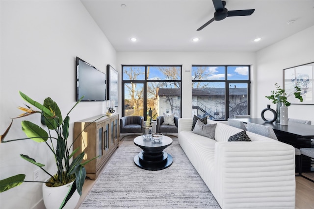 living room with ceiling fan and light wood-type flooring