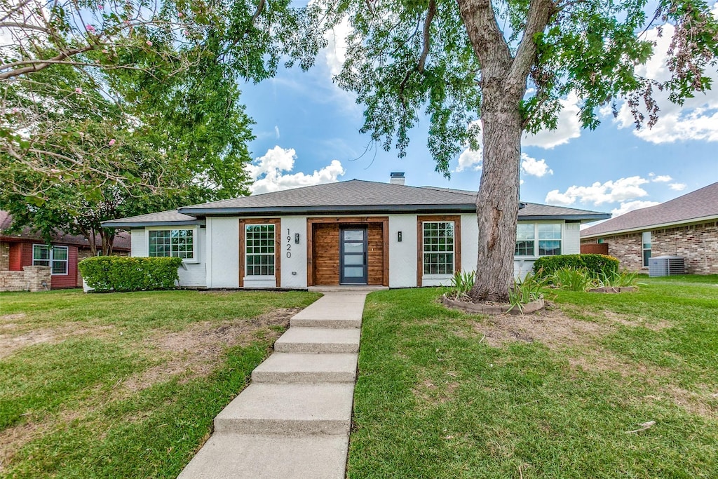 ranch-style house with central AC unit and a front yard