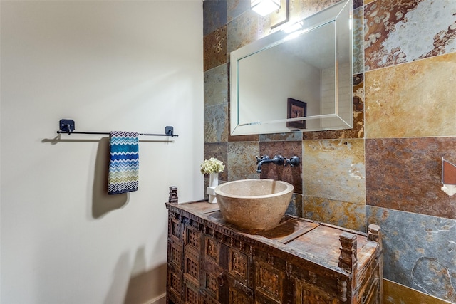 bathroom with tasteful backsplash, vanity, and tile walls