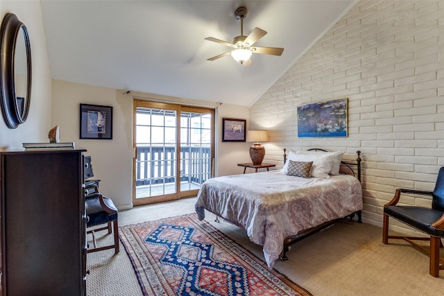 carpeted bedroom featuring access to exterior, vaulted ceiling, ceiling fan, and brick wall