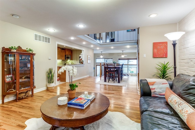 living room with ceiling fan and light wood-type flooring