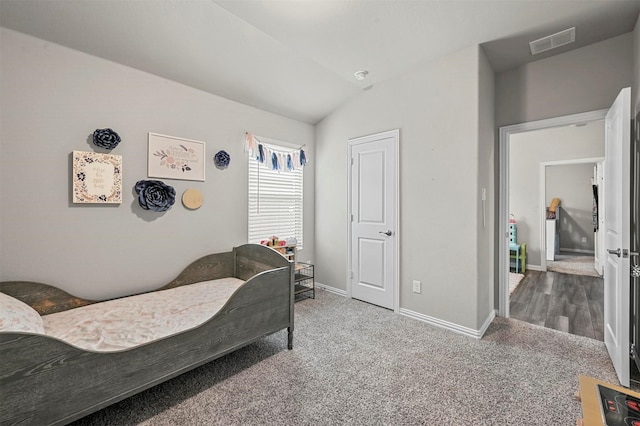 bedroom with carpet floors and vaulted ceiling