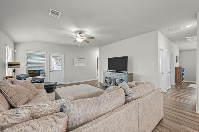 living room featuring vaulted ceiling, a healthy amount of sunlight, ceiling fan, and light hardwood / wood-style flooring