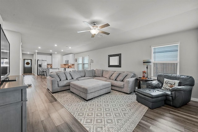 living room with ceiling fan and light wood-type flooring