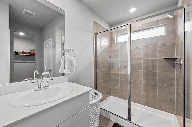 bathroom with vanity and a shower with door