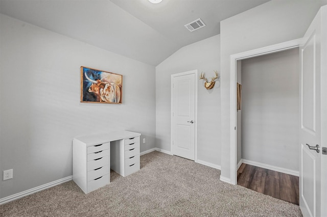 unfurnished bedroom featuring light colored carpet and lofted ceiling