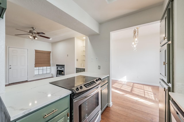 kitchen with ceiling fan, light stone countertops, light hardwood / wood-style floors, green cabinetry, and stainless steel electric range oven