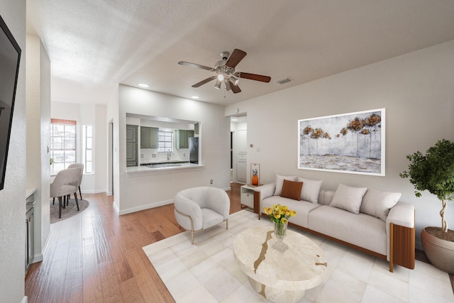 living room with ceiling fan and light wood-type flooring