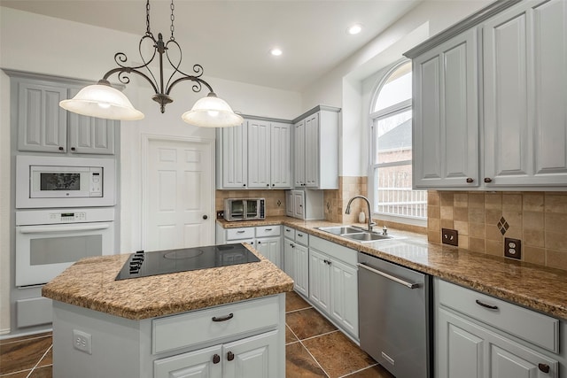 kitchen featuring white appliances, decorative light fixtures, a kitchen island, and gray cabinetry