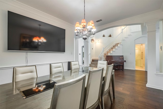 dining room featuring ornate columns, ornamental molding, an inviting chandelier, and dark hardwood / wood-style flooring