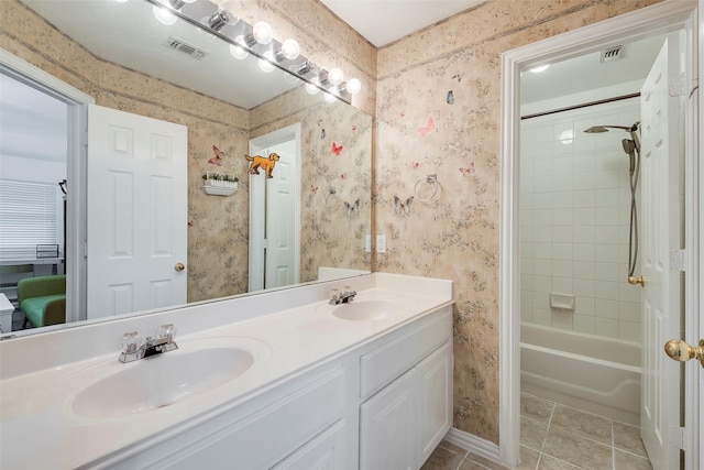 bathroom featuring tiled shower / bath, tile patterned floors, and vanity