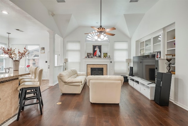 living room with ceiling fan, lofted ceiling, dark hardwood / wood-style floors, and decorative columns