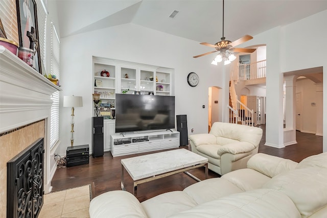 living room with ornate columns, high vaulted ceiling, a fireplace, dark tile patterned flooring, and ceiling fan