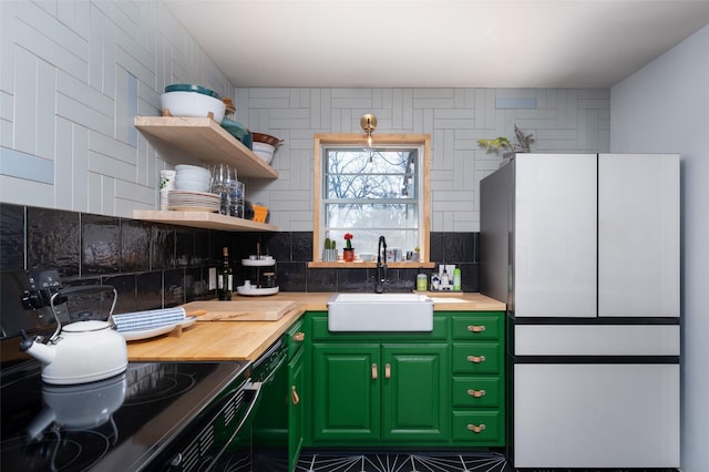 kitchen featuring sink, wooden counters, black appliances, green cabinets, and backsplash