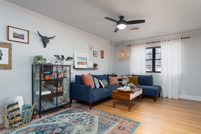 living room with hardwood / wood-style floors, ornamental molding, and ceiling fan