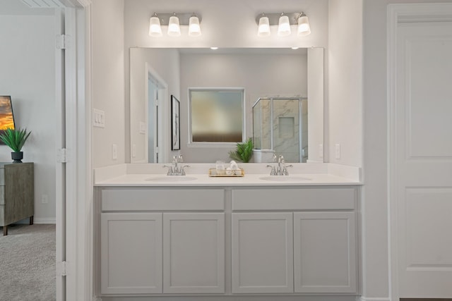 full bathroom with double vanity, a shower stall, and a sink