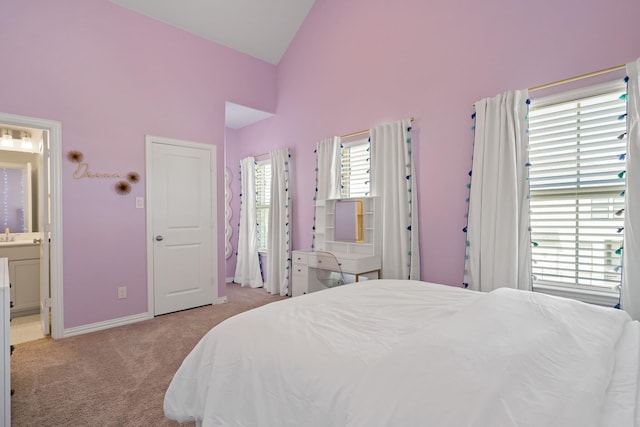 bedroom featuring high vaulted ceiling, light colored carpet, connected bathroom, and baseboards