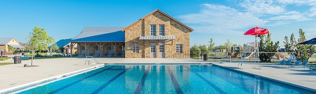 community pool featuring fence and a patio