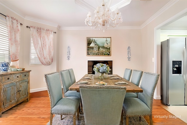 dining space featuring ornamental molding, a chandelier, and light hardwood / wood-style floors