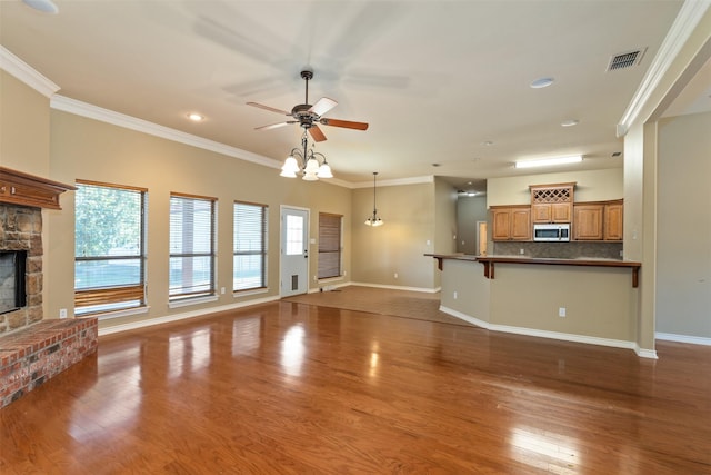 unfurnished living room with dark hardwood / wood-style flooring, crown molding, a fireplace, and ceiling fan