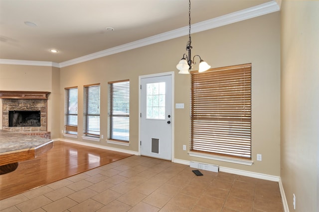 interior space with light tile patterned floors, crown molding, a fireplace, and a notable chandelier