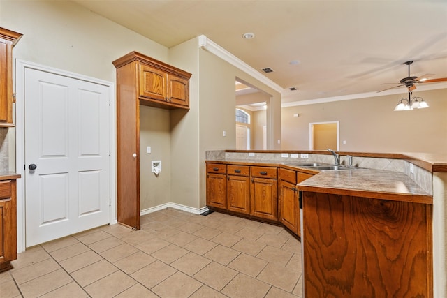 kitchen with sink, ornamental molding, ceiling fan, and light tile patterned flooring