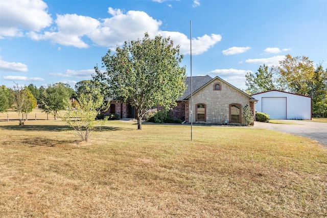 view of front facade with an outbuilding, a garage, and a front lawn