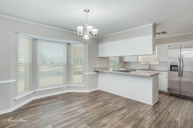 kitchen featuring stainless steel refrigerator with ice dispenser, decorative light fixtures, ornamental molding, kitchen peninsula, and white cabinets