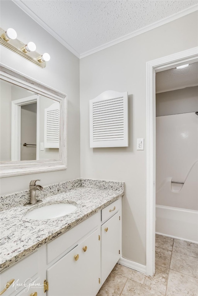 bathroom featuring crown molding, vanity, bathtub / shower combination, and a textured ceiling