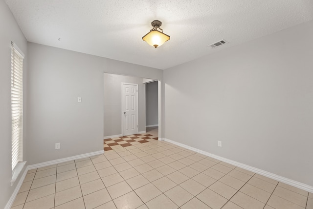 empty room with a wealth of natural light and a textured ceiling