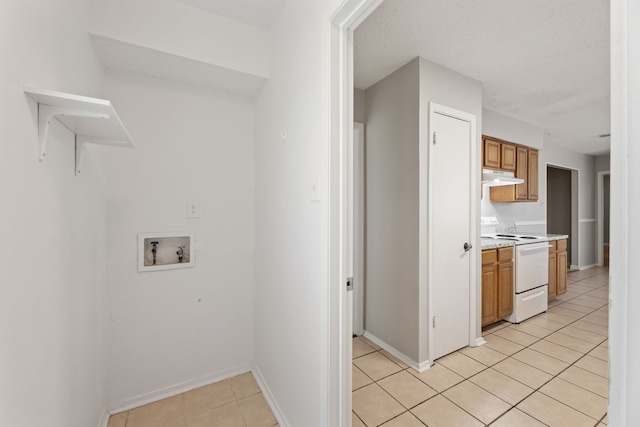 clothes washing area with light tile patterned floors and hookup for a washing machine