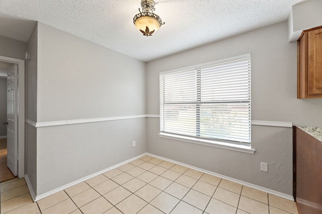 unfurnished dining area featuring a textured ceiling