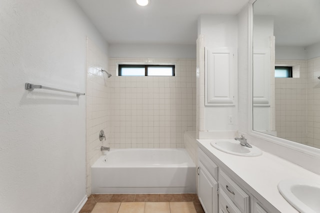 bathroom with tiled shower / bath combo, vanity, and tile patterned flooring